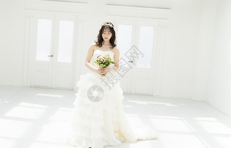 穿着纯白婚纱拿着手捧花的新娘图片