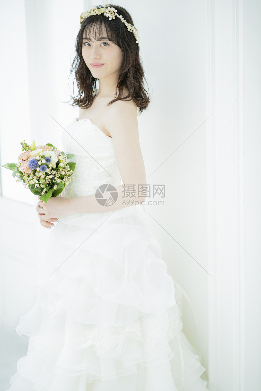 穿着婚纱手拿捧花的婚纱美女图片