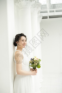 穿着婚纱手拿捧花开心的新娘图片