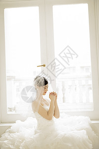 头戴头纱穿着婚纱祈祷的新娘图片