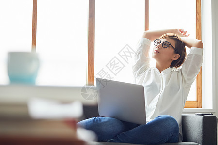 休闲职业女人在沙发上拿着电脑思考年轻高清图片素材