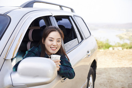 在车上喝水的年轻女人微笑高清图片素材