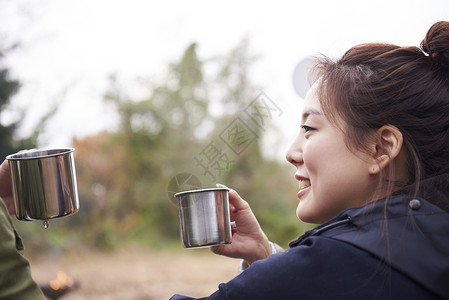 野外露营的年轻女人喝咖啡营地高清图片素材