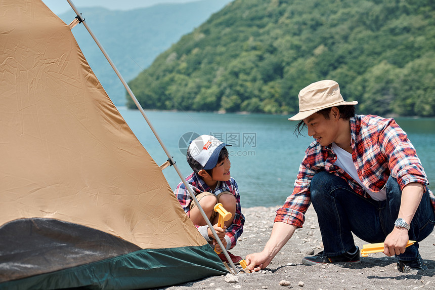 在湖边搭帐篷露营的一家人图片