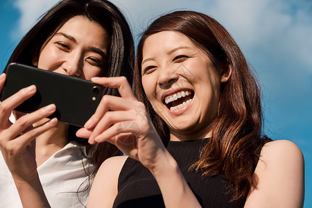 两个女人开心看手机图片
