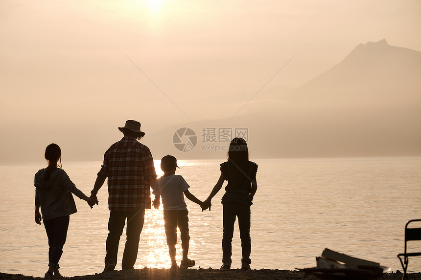 暮色下一家四口户外湖边看风景图片