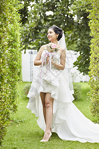 穿着纯白婚纱手拿捧花的新娘图片