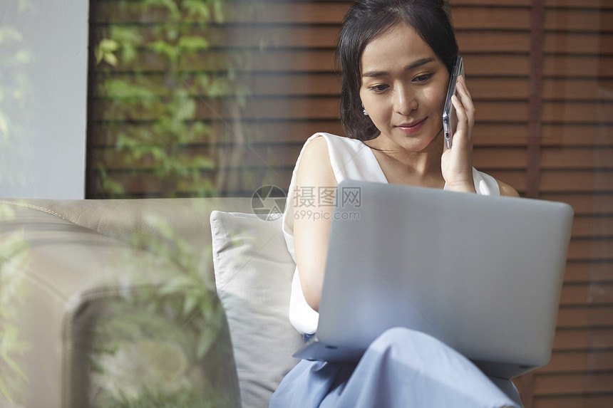 坐在沙发上的职业女性打电话图片