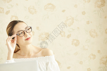 戴着圆框眼镜的年轻女子微笑高清图片素材
