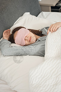 粉色晚安艺术字戴着眼罩熟睡的年轻女子背景