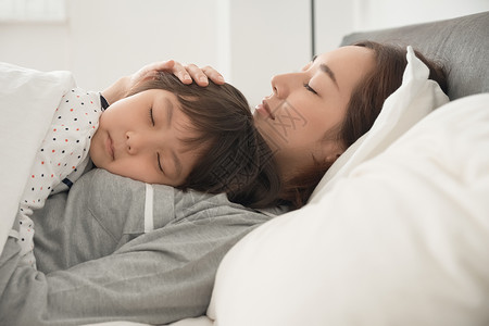壮年日本人小姑娘父母和孩子睡在床上图片