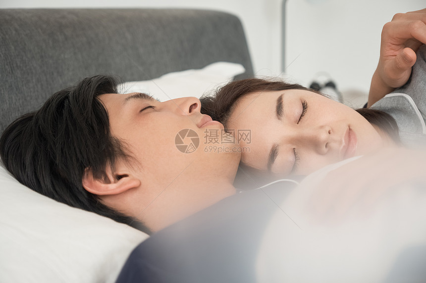 幸福笑脸好朋友睡在床上的一对夫妇图片