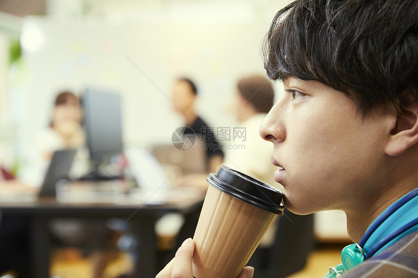 手拿咖啡杯的商务男青年图片