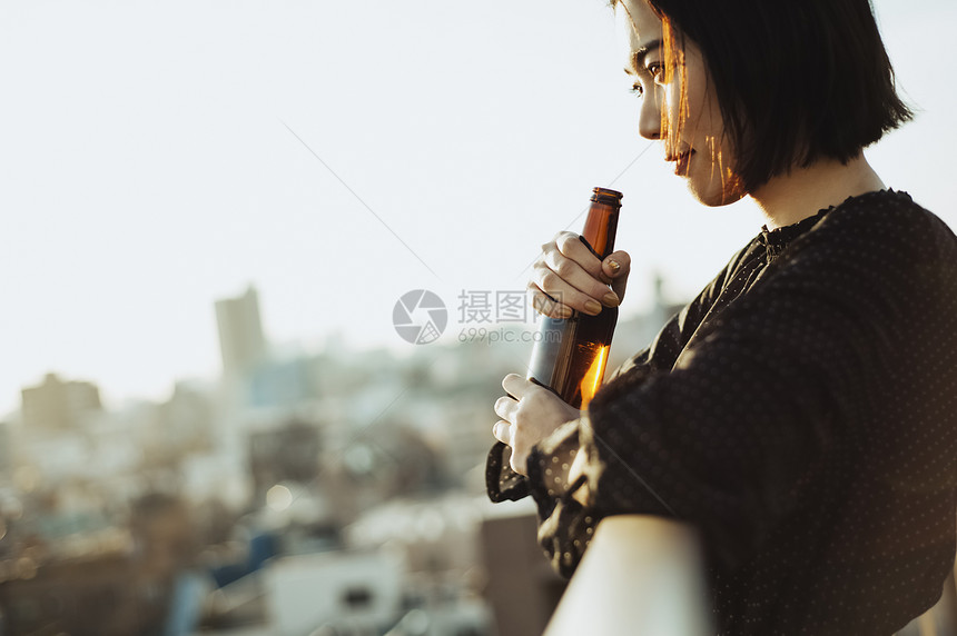 屋顶上喝酒的女人图片