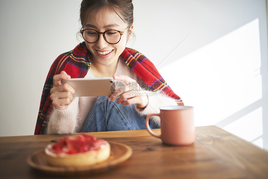 美丽的女人在家拍美食图片