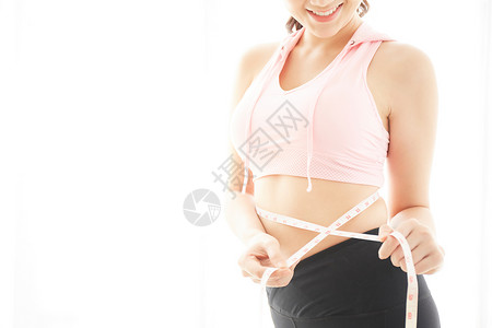 运动女性正在用皮尺量腰围图片