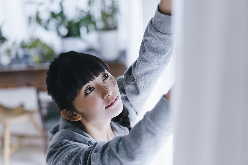 拉窗帘独自生活的女人图片