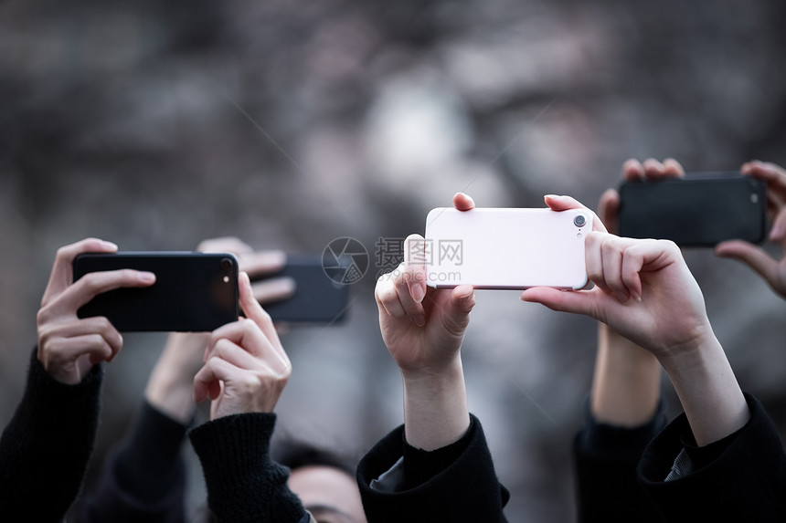人们举着手机拍照特写图片
