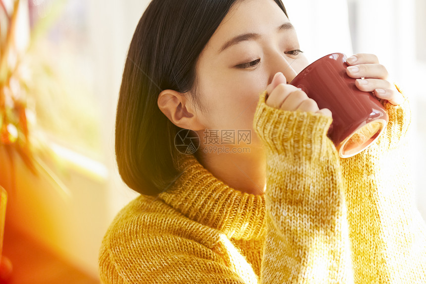 穿着毛衣喝咖啡的女孩图片