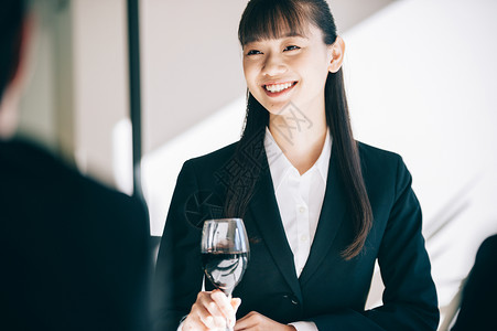 欢迎宴会上司亚洲得到一杯酒的新的新兵妇女在餐馆图片