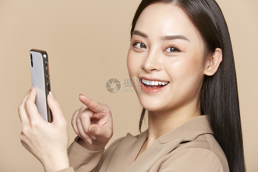 使用手机微笑的商务女性图片
