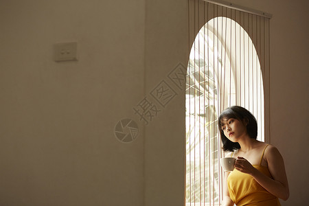 窗边喝咖啡享受下午茶的女青年礼服高清图片素材