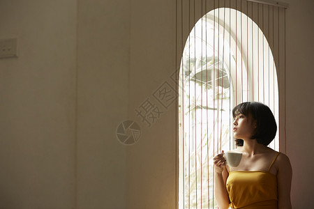 窗边喝咖啡享受下午茶的女青年窗口高清图片素材