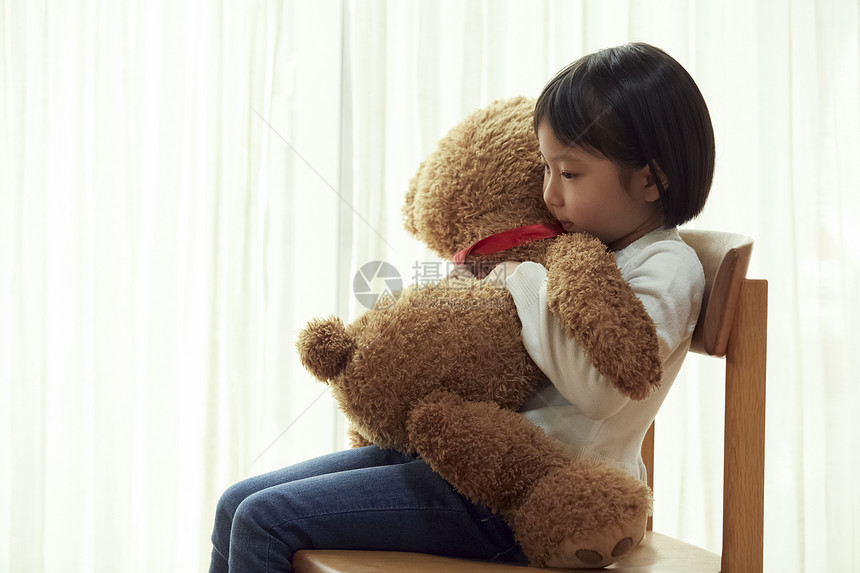 青春生日玩偶使用与一头大熊的女孩坐椅子图片