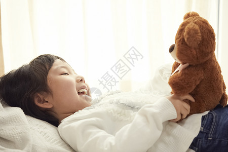 最好的朋友毛绒玩具幼儿睡觉与小熊的女孩在床上图片