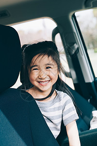 坐在汽车后座上微笑的女孩旅游高清图片素材