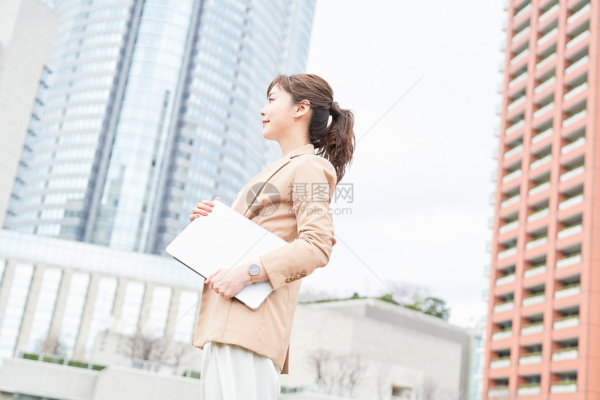 抱着笔记本电脑的女性图片