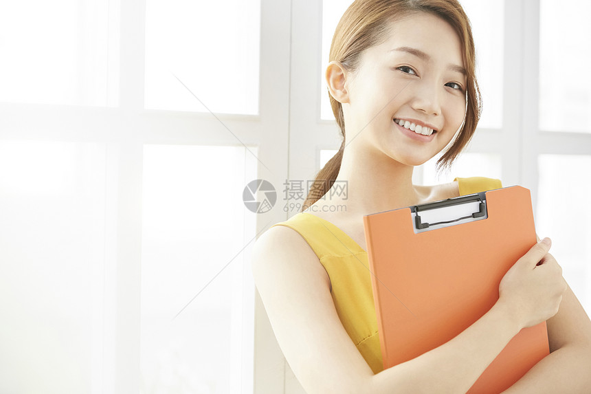 青年职业女性抱着文件夹图片