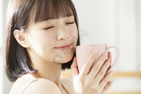 捧着水杯闭眼微笑的年轻女子外国人高清图片素材