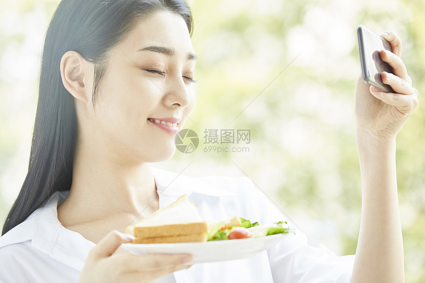 拿手机拍食物的居家女孩图片