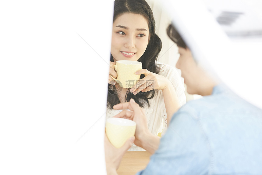 年轻情侣坐在一起喝茶图片
