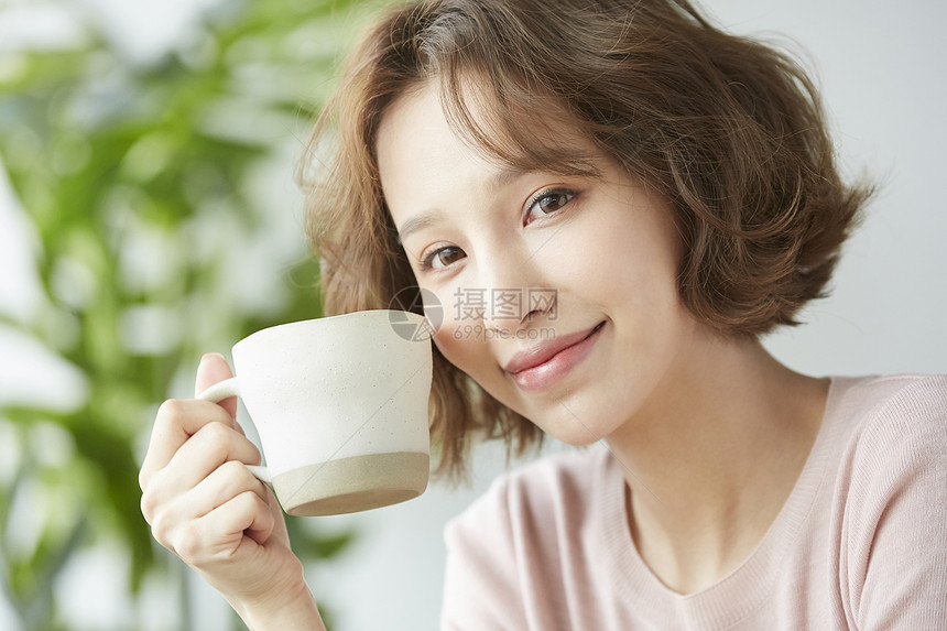 拿着杯子微笑的年轻女子图片