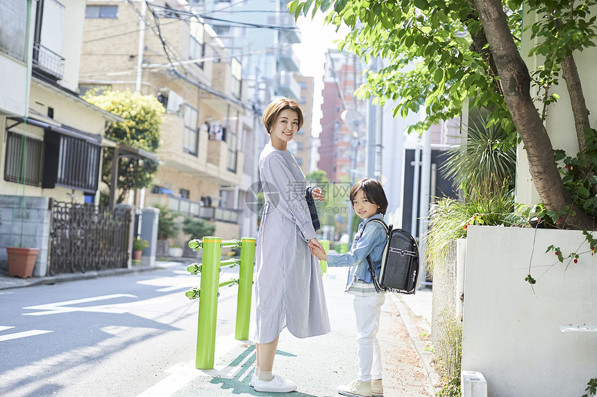 年轻妈妈接小男孩放学回家图片