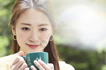 年轻女人放松喝茶脸高清图片素材