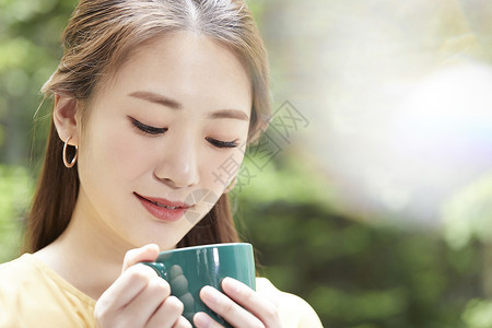 手拿咖啡喝下午茶的青年女子茶杯高清图片素材