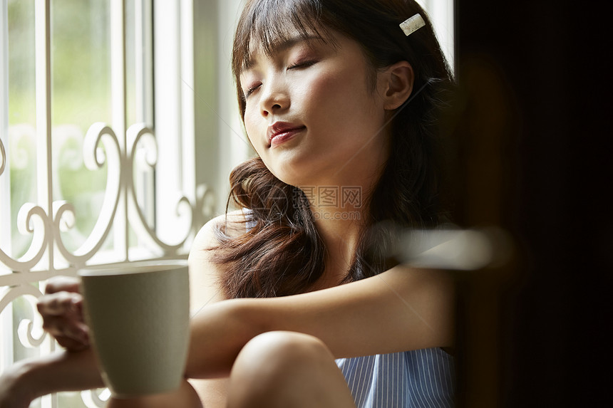 室内窗边喝茶的女人图片