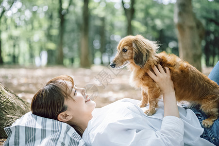 公园里带着宠物狗的女人图片