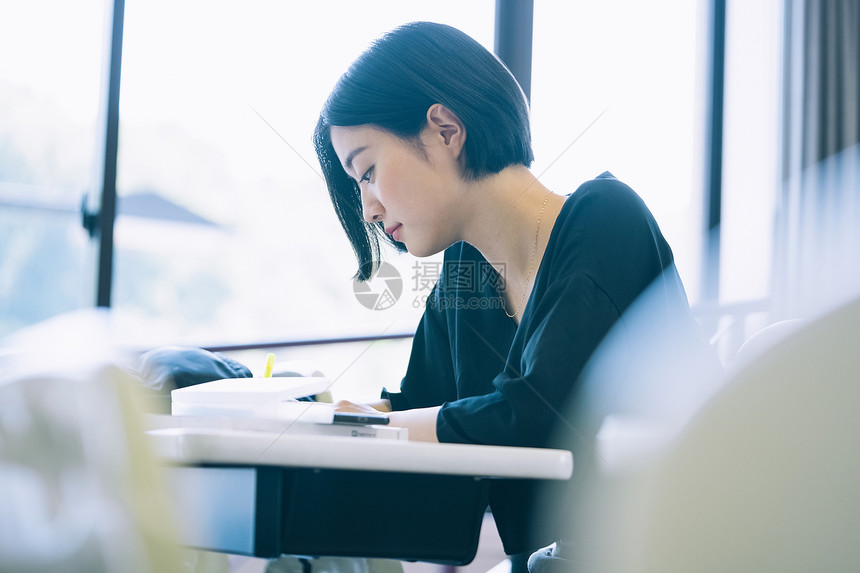 上课记笔记本的女大学生图片