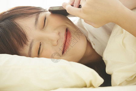 可爱女生开心的在床上讲电话孤独的高清图片素材