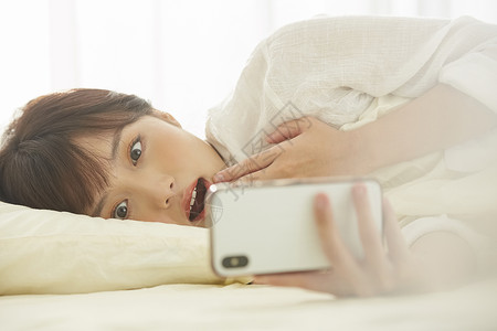 可爱女生开心的在床上看手机漂亮高清图片素材