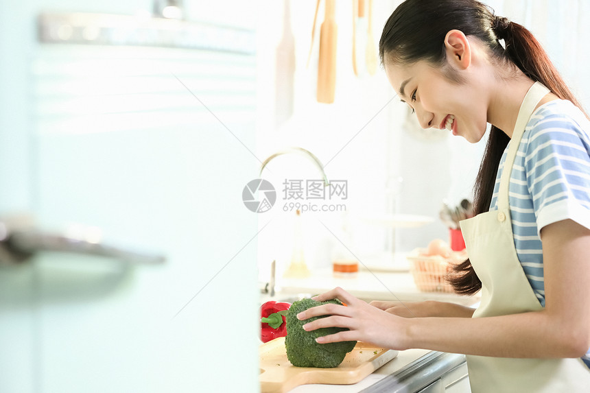 愉快的女人在厨房做美食图片
