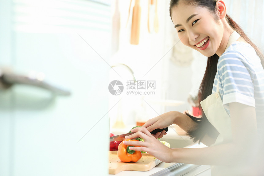 愉快的女人在厨房做美食图片