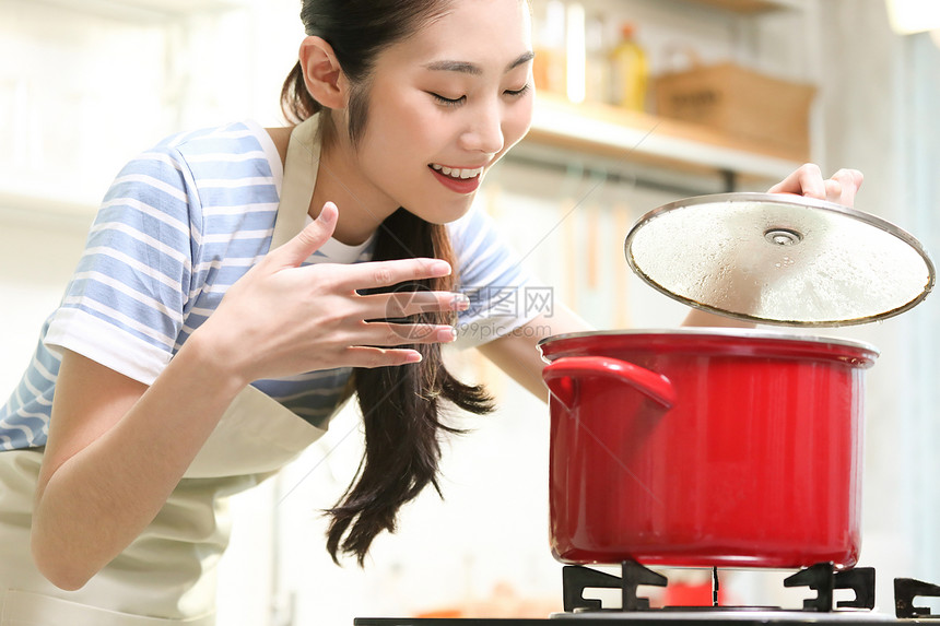 愉快的女人在厨房做美食图片