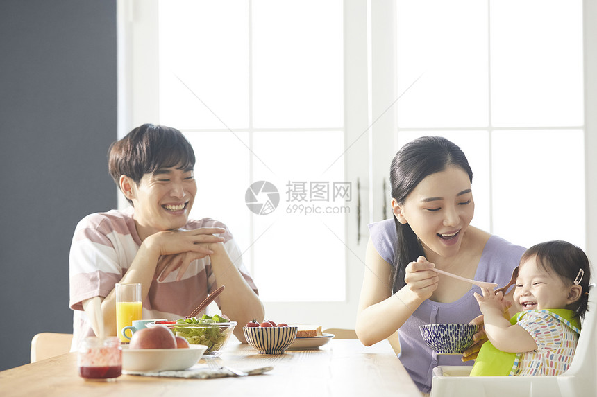 年轻夫妇照顾孩子吃饭图片