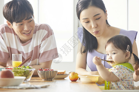 愉快的一家人照顾着小孩饮食图片