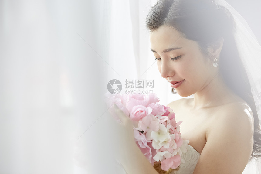 披着婚纱的新娘抱着手捧花图片